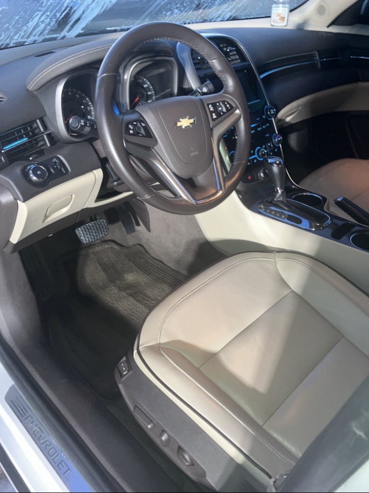 The clean tan leather interior and dashboard of a freshly detailed Chevy Malibu